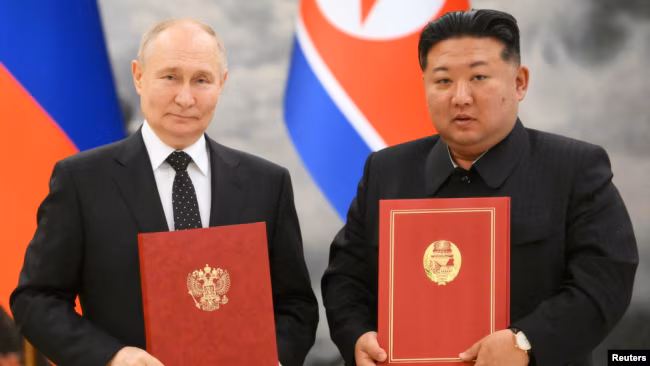 Presiden Rusia Vladimir Putin dan pemimpin Korea Utara Kim Jong-un, berpose usai menandatangani pakta pertahan