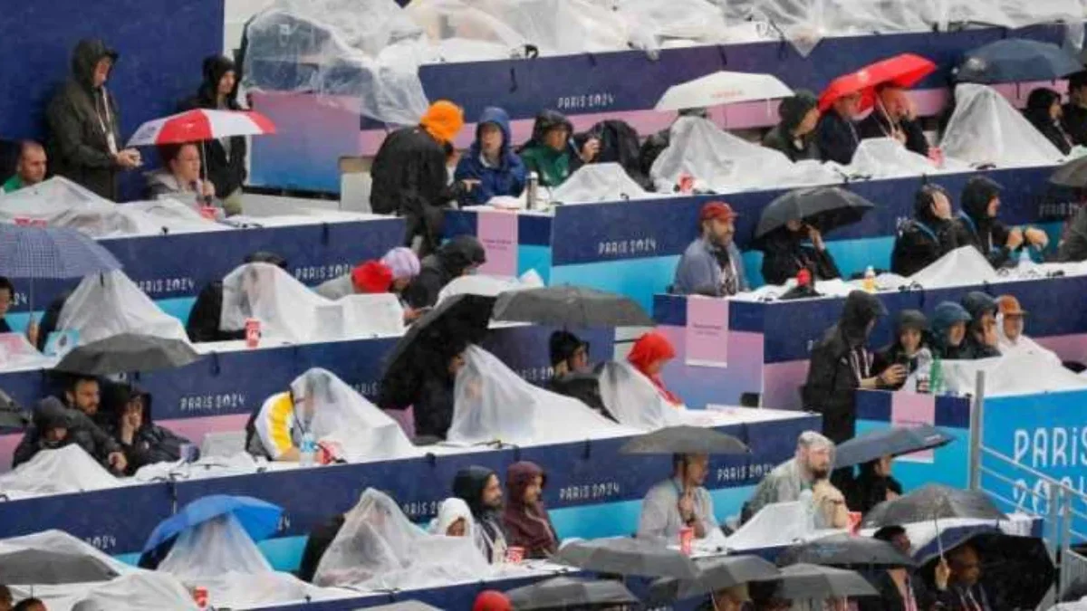 Area Media Center Olimpiade Paris 2024 Ditutup: Ada Risiko Ledakan Awak media yang mengenakan jas hujan menyaksikan delegasi yang tiba di Trocadero selama upacara pembukaan Olim