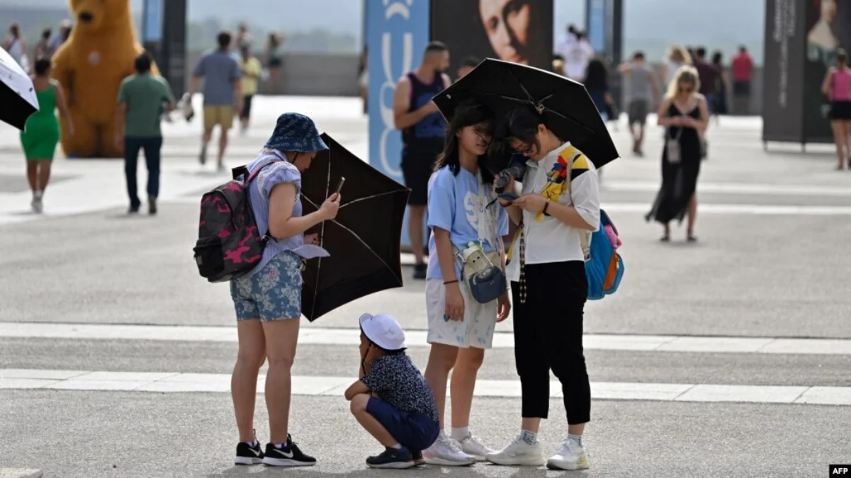 Laporan ISGlobal: 47.000 Orang di Eropa Meninggal Akibat Suhu Panas Sepanjang 2023 Turis berlindung dari terik matahari dengan payung di depan Istana Kerajaan di Madrid pada 18 Juli 2023. (Foto