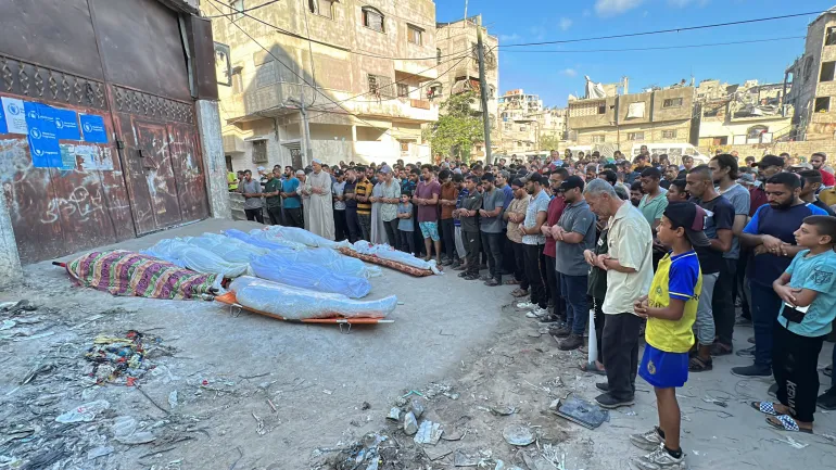 Kasus Genosida Israel di Gaza: 41.200 Tewas 173 Jurnalis, Desak Amerika Serikat Kirim Senjata Warga Palestina berdoa di samping jenazah beberapa orang yang tewas dalam serangan Israel di sekolah di Kota G