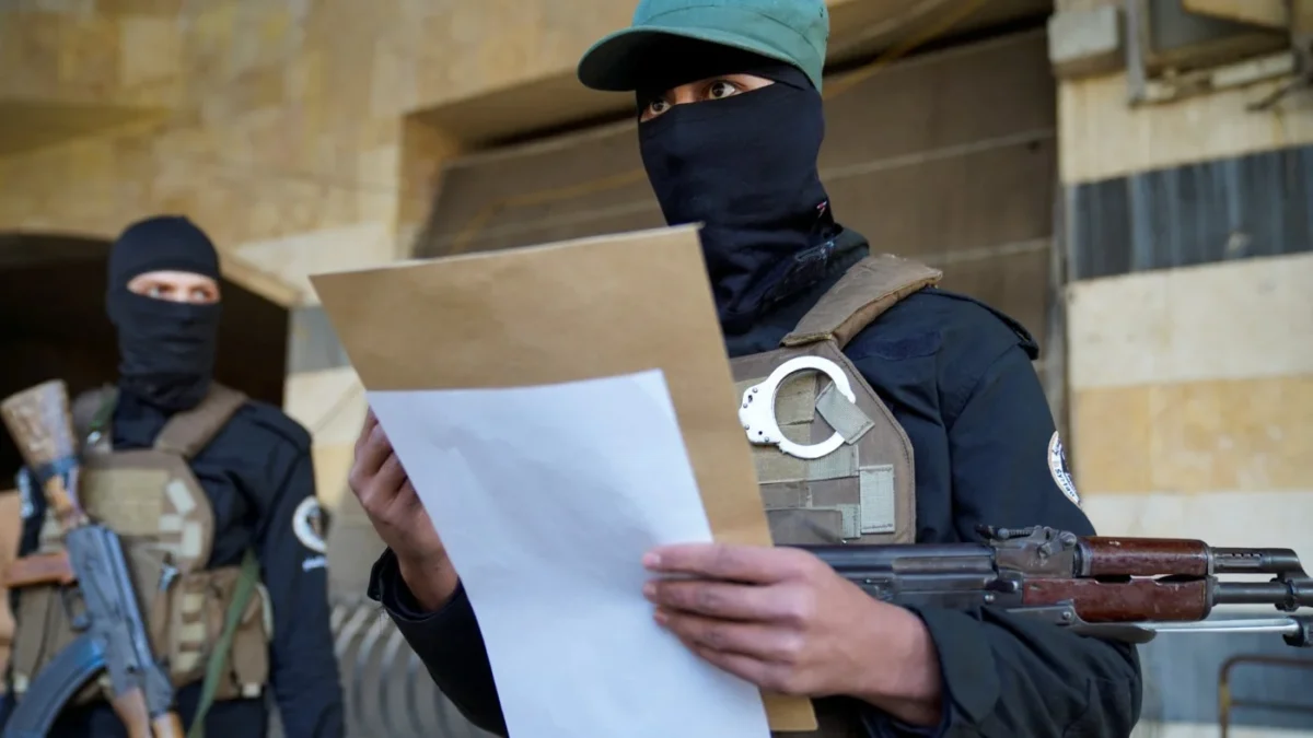 Kemlu Telusuri Kemungkinan Warga Indonesia Bergabung dengan Kelompok Hayat Tahrir Al-Sham (HTS) di Suriah Seorang pemberontak, dipimpin oleh kelompok Hayat Tahrir al-Sham (HTS), di kantor polisi yang direbut oleh pem