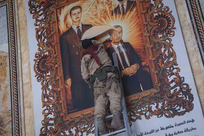 Presiden Suriah Bashar al-Assad Berikut Menteri Pertahanan Ali Mahmoud Abbas Belum Diketahui Keberadaannya Seorang pemberontak dan gambar Presiden Suriah, Bashar al Assad, dan ayahnya Hafez al Assad, di bandara intern