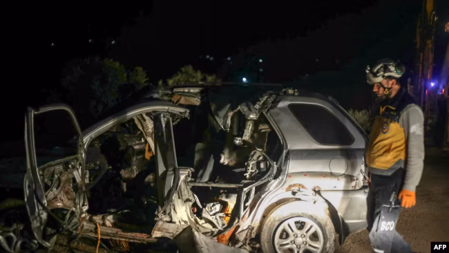 Muhammad Salah al-Zabir, Agen Senior Al Qaeda di Suriah Tewas Seorang petugas SAR dari Helm Putih memeriksa bangkai mobil di lokasi serangan udara oleh koalisi AS yang meny