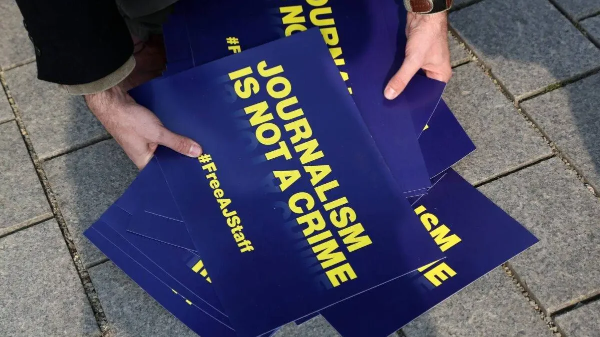 Seorang jurnalis mengumpulkan tanda bertuliskan ‘Jurnalism is not a Crime’ 27 Februari 2014 (Adam Berry/Getty