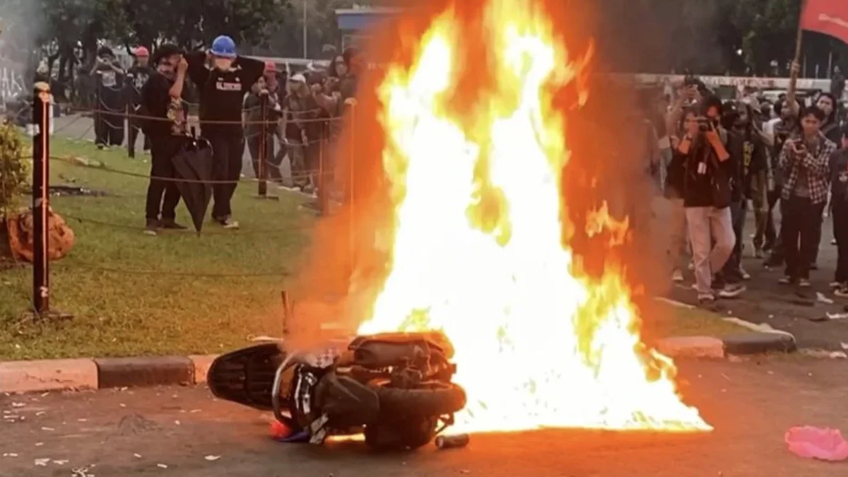 Massa saat menyeret lalu membakar motor berpelat nomor polisi yang melintas di depan Gedung DPR/MPR RI.