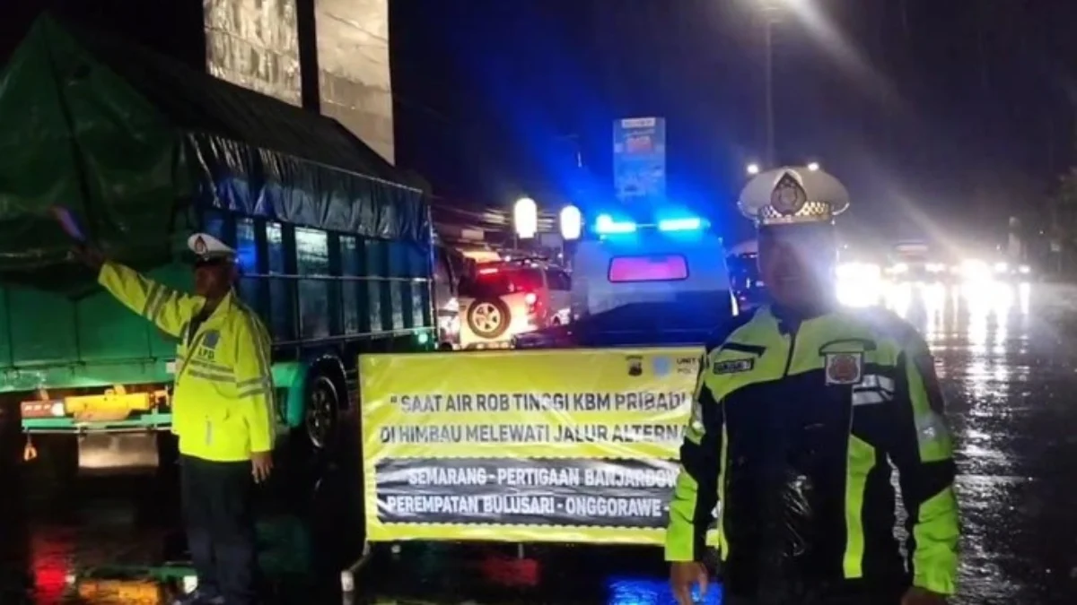 Petugas Polsek Genuk mengatur lalulintas di Simpang Genuksari karena ada rob di Sayung, Jumat (28/3/2025). Fot