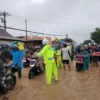 Petugas mengatur arus lalu litas ditengah banjir yang membuat jalan utama Slawi ke Bumiayu lumpuh pada arus mu