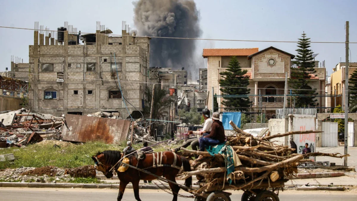 Dua orang pria mengendarai kereta kuda membawa kayu menyaksikan kepulan asap yang keluar dari serangan udara I