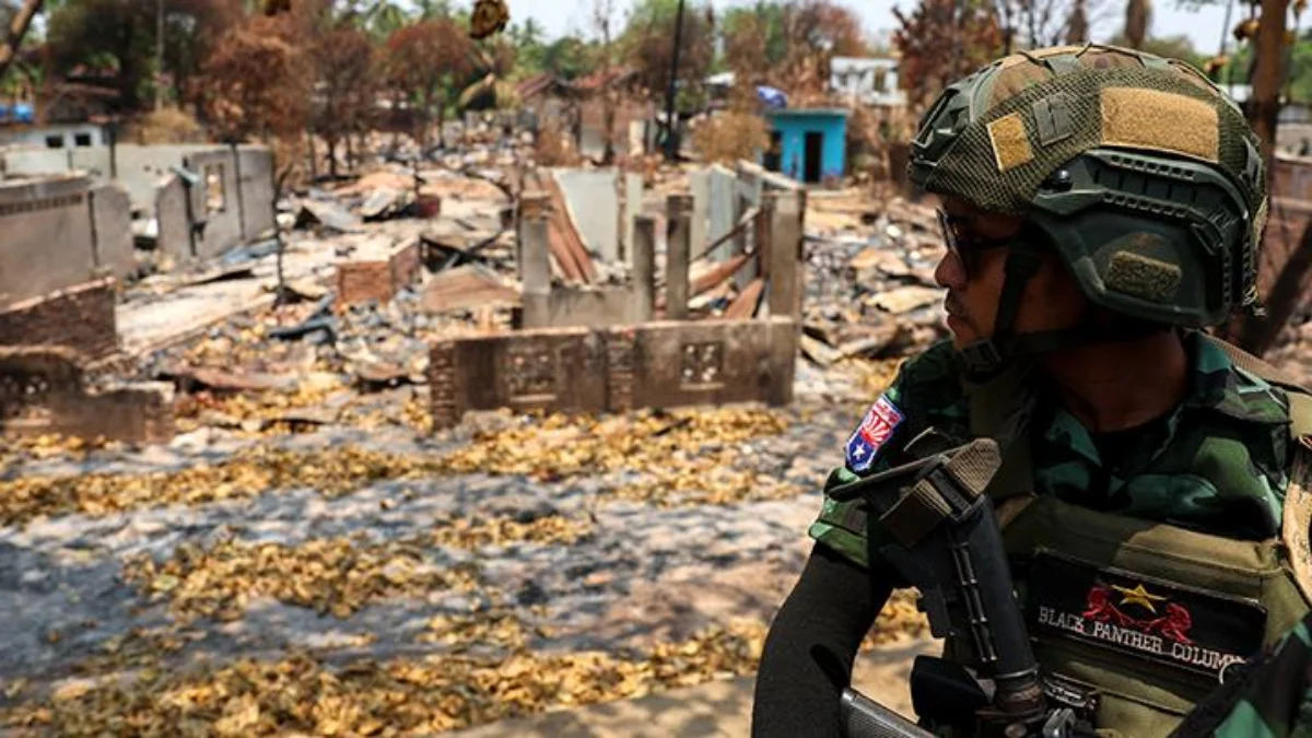 Seorang tentara dari Tentara Pembebasan Nasional Karen (KNLA) berpatroli dengan kendaraan, di samping area yan
