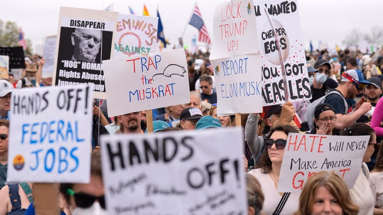 Para demonstran mengangkat spanduk protes \