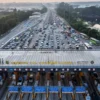 Foto udara sejumlah kendaraan pemudik melaju perlahan di Gerbang Tol Cikampek Utama, Karawang, Jawa Barat, Min