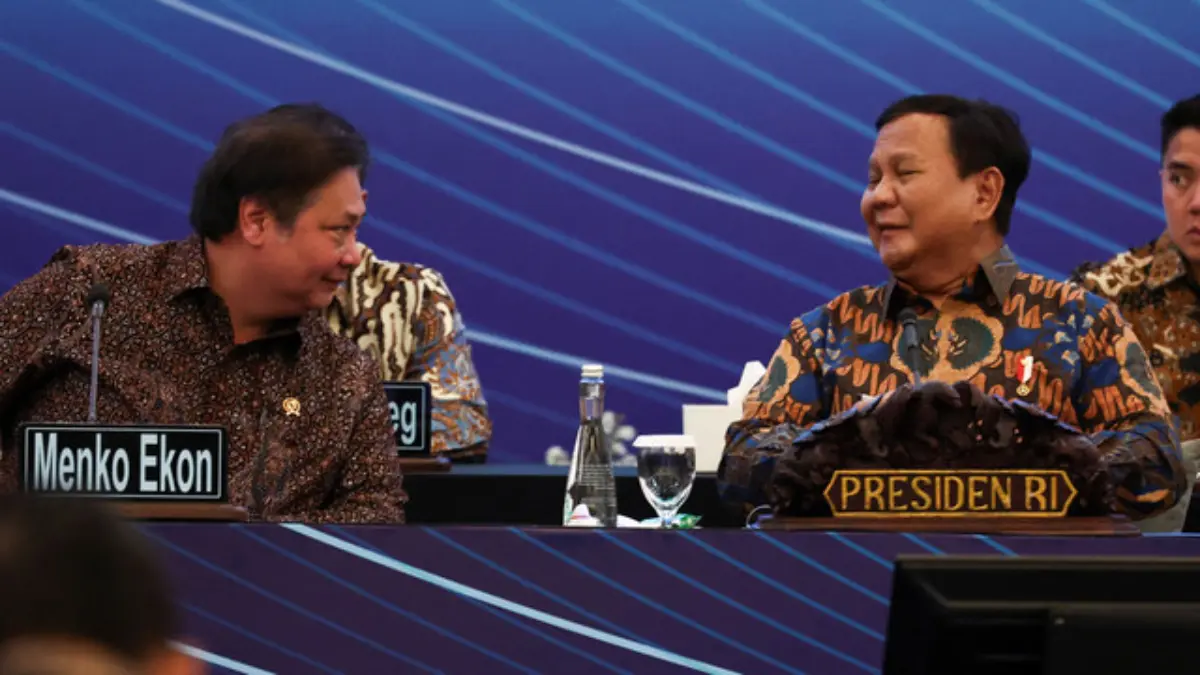 Presiden Indonesia Prabowo Subianto bereaksi saat berbicara dengan Airlangga Hartarto, Menteri Perekonomian In