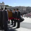 Para pengusung jenazah mengangkat peti jenazah Paus Fransiskus untuk segera dibawa dalam prosesi ke gereja San