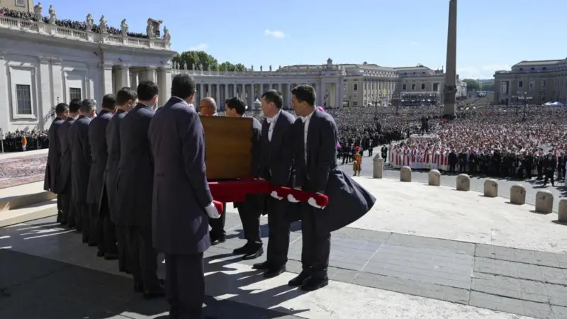 Para pengusung jenazah mengangkat peti jenazah Paus Fransiskus untuk segera dibawa dalam prosesi ke gereja San