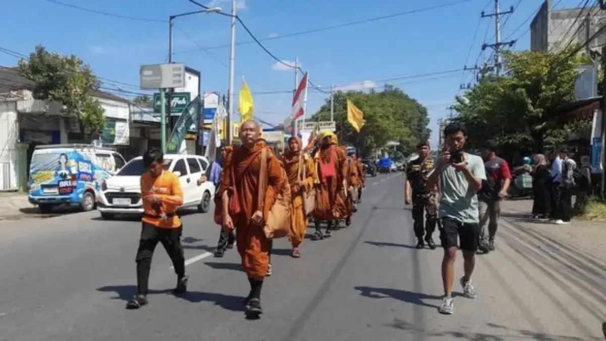 Sejumlah biksu yang mengikuti ritual Thudong menyapa warga saat berjalan kaki di Kabupaten Kendal, Jawa Tengah