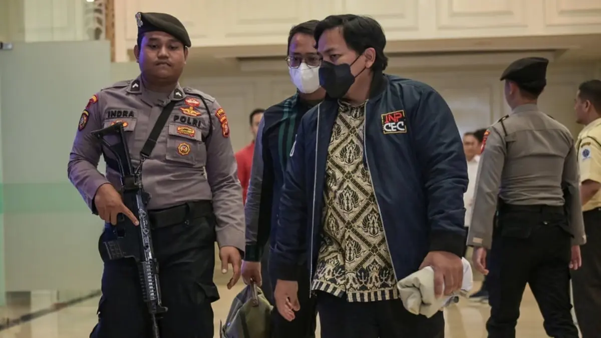 Petugas KPK bersama polisi berjalan keluar usai melakukan penggeledahan di Kantor Kementerian Ketenagakerjaan,