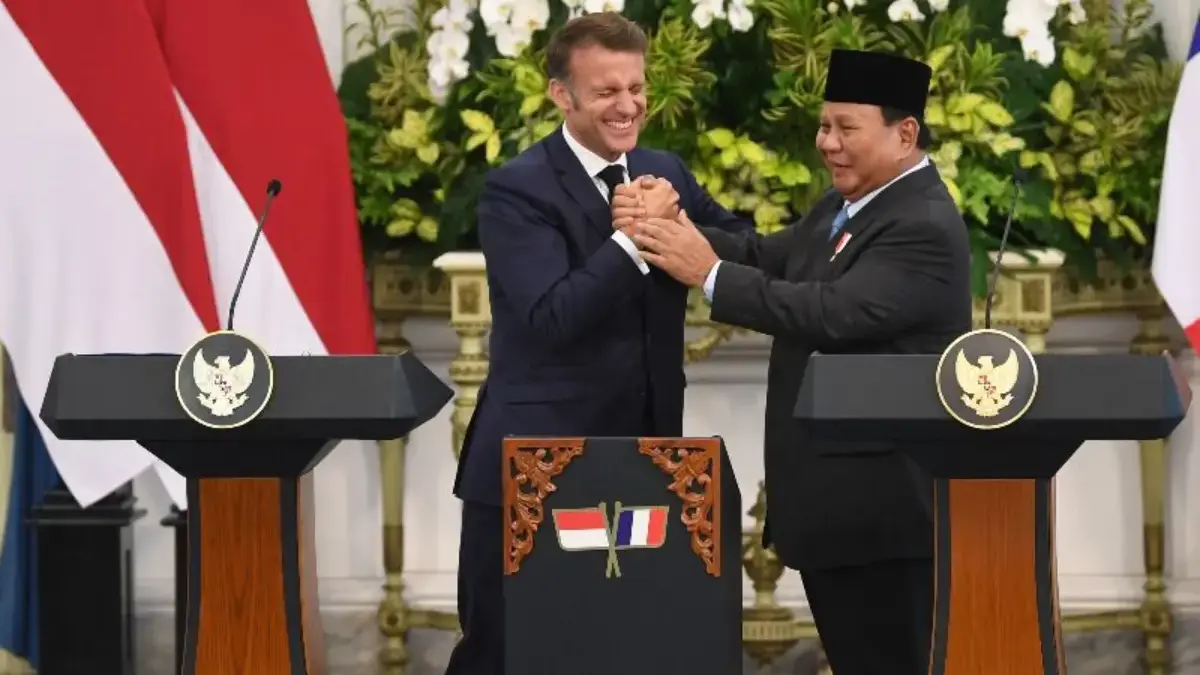 Presiden Prabowo Subianto (kanan) menggenggam tangan Presiden Prancis Emmanuel Macron usai menyampaikan pernya