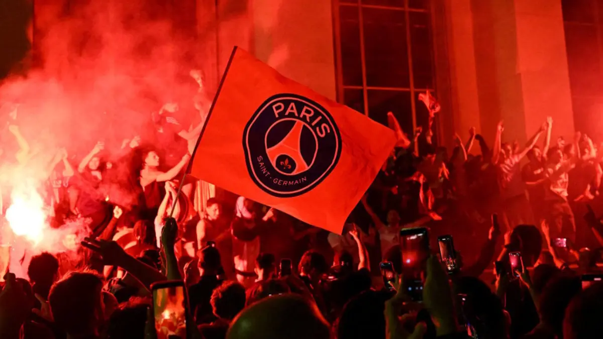 Para pendukung Paris Saint-Germain (PSG) menyalakan suar saat berkumpul di Place Trocadero di depan Menara Eif