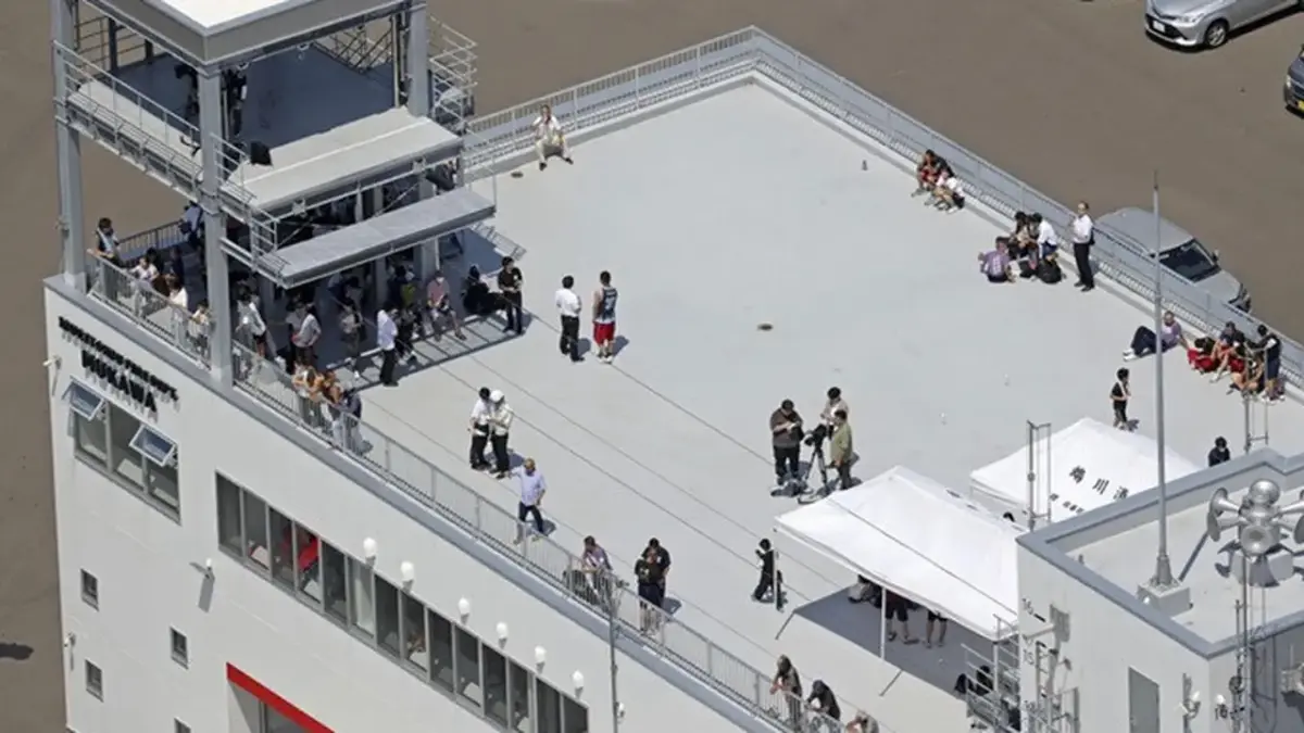 Warga berlindung di atap sebuah pos pemadam kebakaran di Kota Mukawa, Hokkaido, Jepang utara, Rabu, (30/7/2025