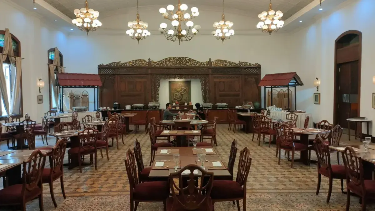 Meja dan kursi di restoran terbuat dari kayu jati antik yang dirawat dengan baik, menambah kesan autentik bagi