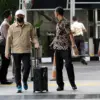 Abdul Azis berjalan ke dalam gedung KPK sambil membawa koper hitam tanpa menggunakan rompi tahanan dan tangan