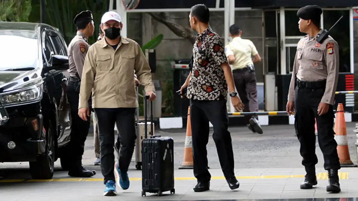 Abdul Azis berjalan ke dalam gedung KPK sambil membawa koper hitam tanpa menggunakan rompi tahanan dan tangan