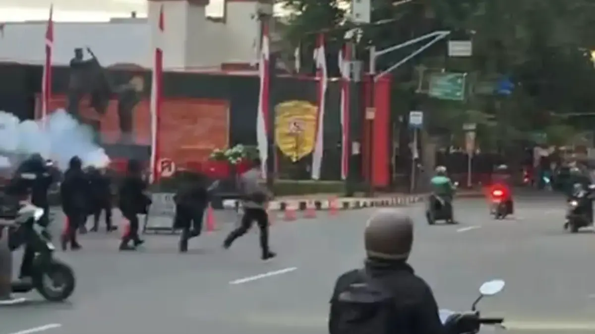 Aparat kepolisian berjaga dan menembakkan gas air mata saat massa melakukan aksi anarkis di depan Markas Brimo