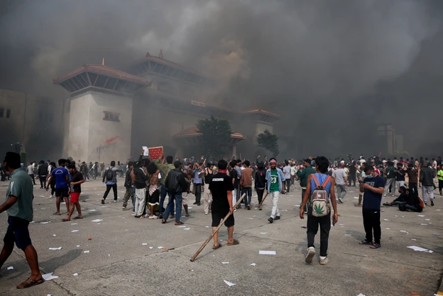 Demonstrasi di Nepal, Pola 'Sangat Mirip dan Mencurigakan' dari Bangladesh, Sri Lanka hingga Indonesia Demonstran berkumpul saat asap mengepul di kompleks Parlemen, Kathmandu, Nepal, Selasa (9/9/2025). Foto: Adnan