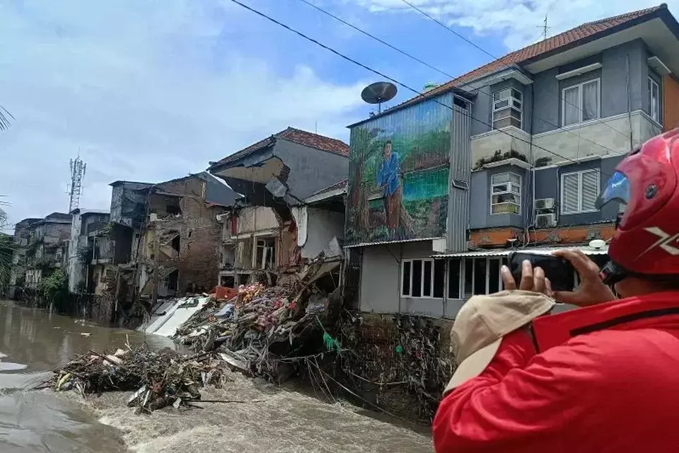 Warga menyaksikan bangunan ruko yang hancur dihantam banjir di Jalan Sulawesi, Denpasar, Bali, Rabu 10 Septemb