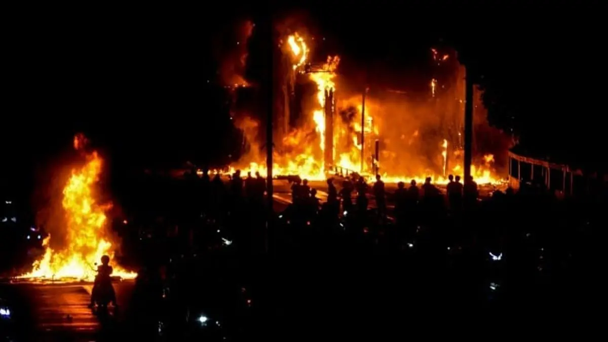 Pengunjuk rasa melihat gerbang tol Pejompongan yang terbakar saat demonstrasi di Jakarta pada Jumat (29/8/202