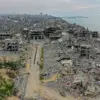 Lokasi pengungsian di Gaza dengan latar belakang Pelabuhan Gaza menjorok ke Laut Mediterania hancur lebur akib