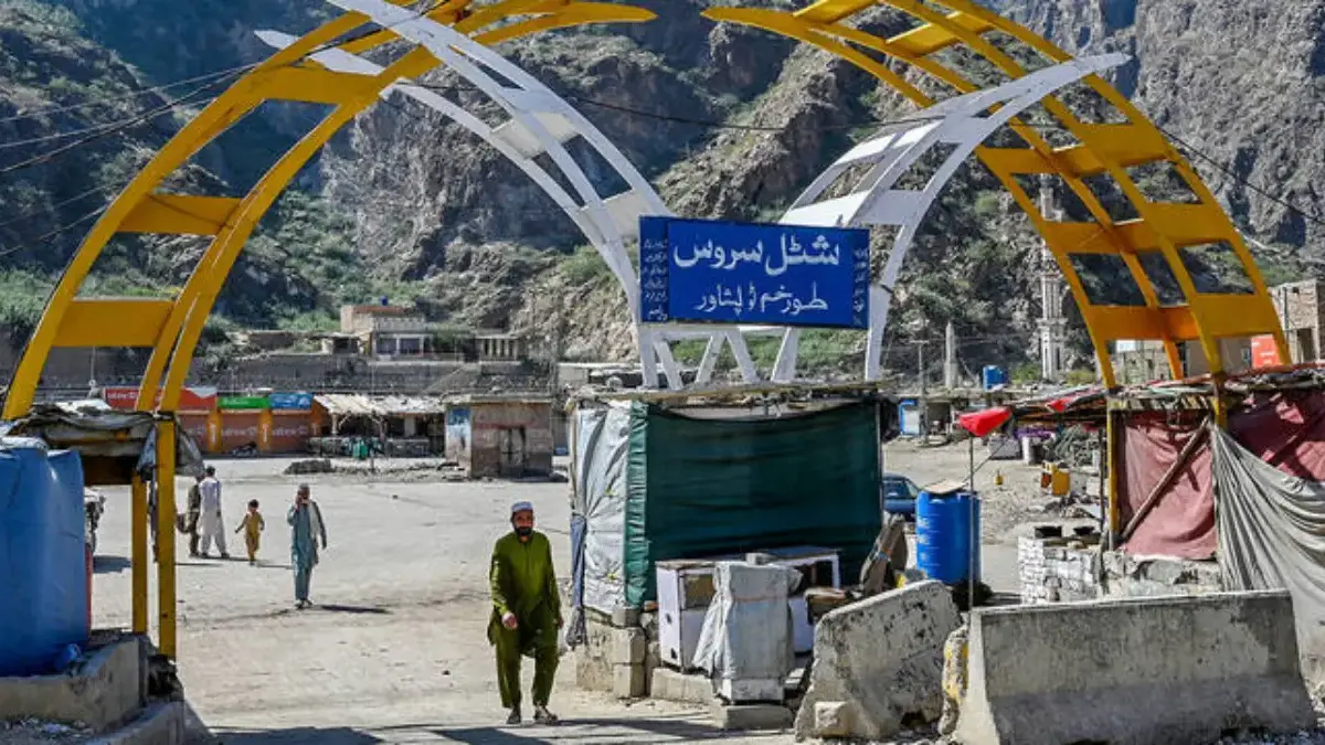 Seorang pria berjalan melintasi halte bus di kota perbatasan Pakistan-Afghanistan Torkham pada 13 Oktober 2025