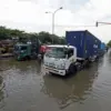 Sejumlah truk melintas jalan Kaligawe Raya yang terendam banjir di Kota Semarang, Jawa Tengah, Rabu (29/10). (