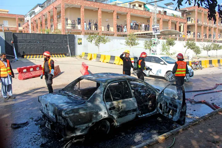 Petugas pemadam kebakaran usai memadamkan api di sebuah mobil di lokasi ledakan bom bunuh diri di Islamabad, P