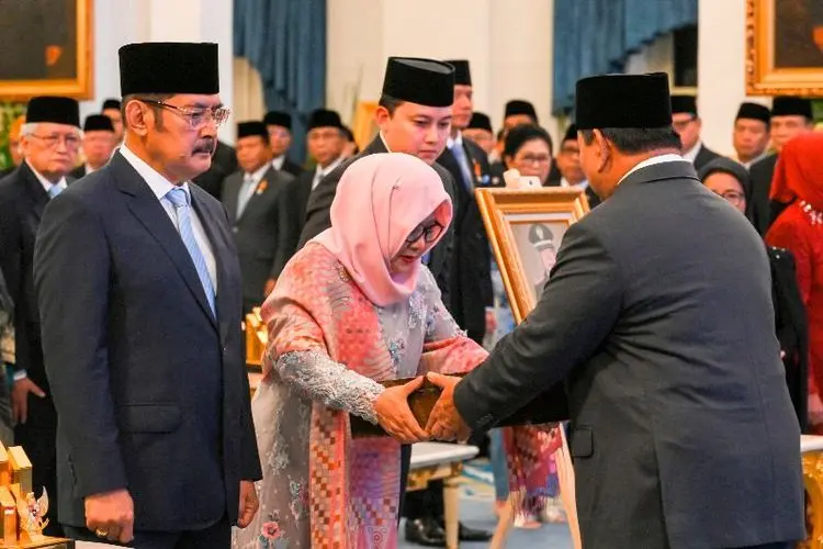 Presiden Prabowo Subianto (kanan) menyerahkan anugerah gelar pahlawan nasional kepada anak Jenderal Besar TNI