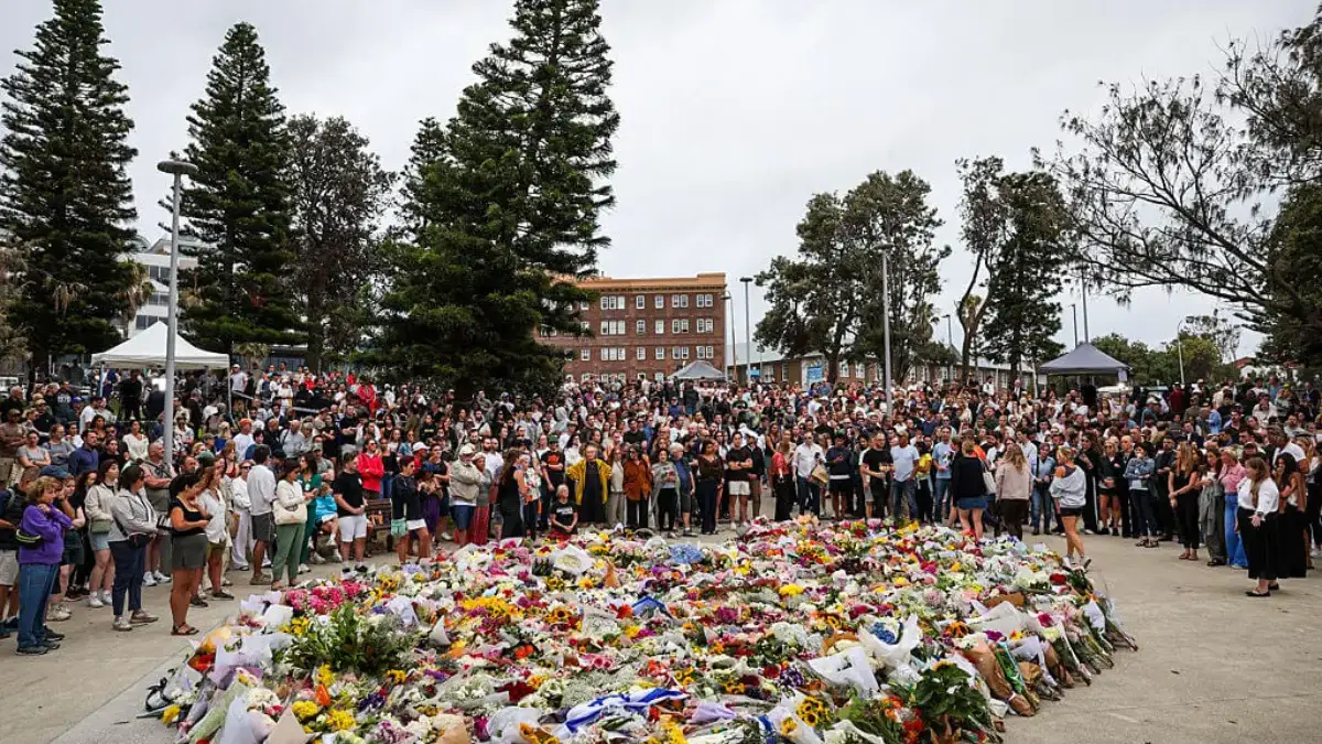 Para pelayat berkumpul untuk meletakkan bunga di Pantai Bondi di Sydney. Polisi mengatakan 15 orang tewas dan
