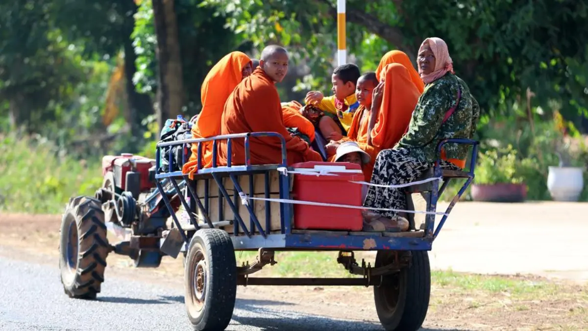 Dalam foto ini dirilis oleh Agence Kampuchea Press (AKP), penduduk desa Kamboja, diangkut dengan traktor, mela
