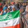 Seorang wanita menampilkan bendera Somaliland saat orang-orang mengantri untuk memberikan suara mereka selama
