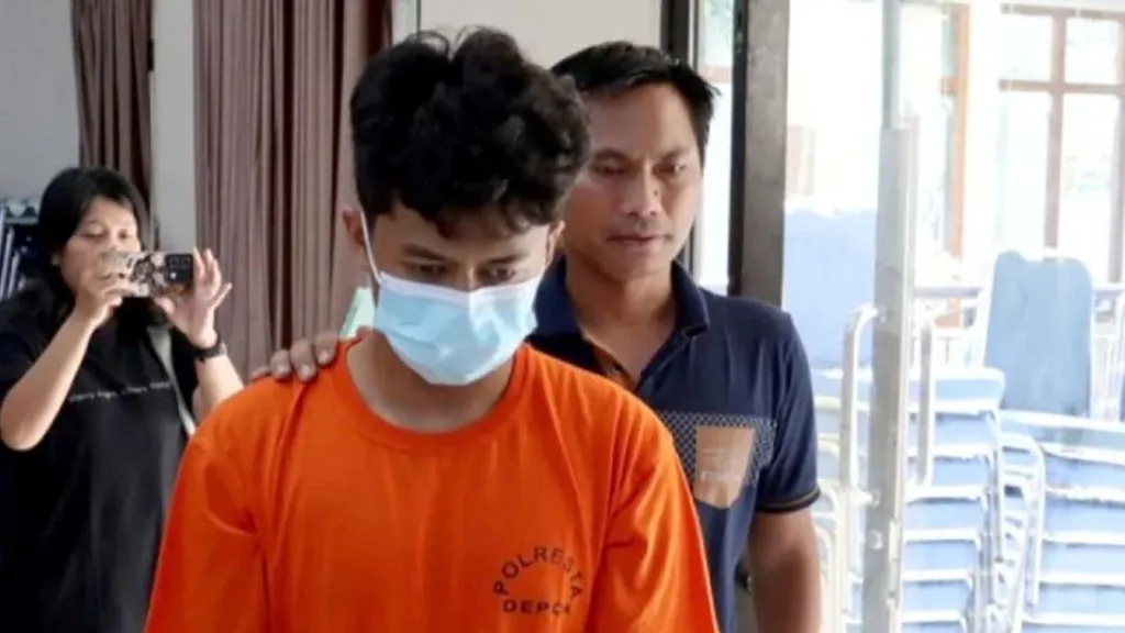 Tersangka H, pelaku kasus teror bom terhadap 10 sekolah di Depok, Jawa Barat, saat dibawa ke Polres Metro Depo