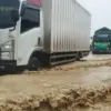 Anggota Polsek Genuk saat sedang mengatur lalu lintas di Jalan Pantura Demak-Semarang yang tergenang banjir.