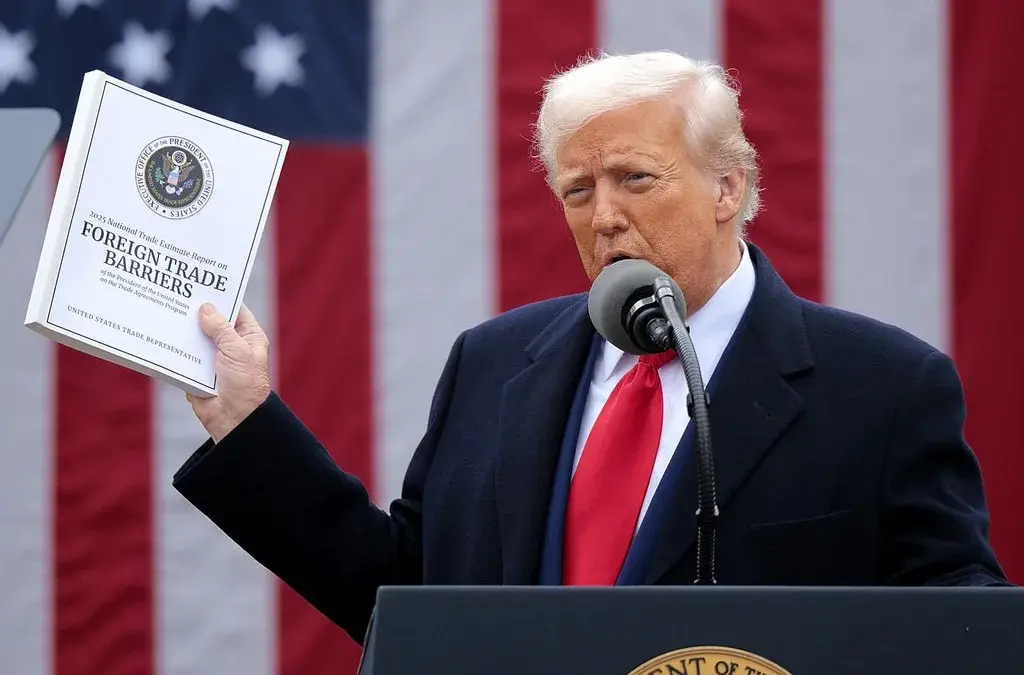 Presiden AS Donald Trump mengangkat salinan Laporan Estimasi Perdagangan Nasional 2025 saat ia berpidato dalam