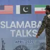 Seorang anggota militer Pakistan berjalan melewati papan reklame perundingan perdamaian AS-Iran di Islamabad,