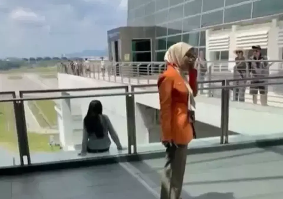 Seorang WNA wanita asal China duduk terlihat duduk di balkon Bandara Internasional Kuala Lumpur sebelum akhirn