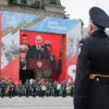 Seorang tentara melihat layar saat presiden Rusia, Vladimir Putin, berpidato di parade militer Hari Kemenangan
