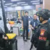 Personel Brimob Polda Metro Jaya mengamankan markas judi online dan penipuan internasional di Hayam Wuruk. (IS