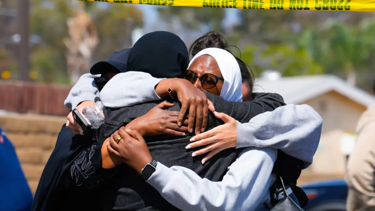 Anggota komunitas muslim berpelukan dari tempat insiden penembakan di San Diego, California, AS, 18 Mei 2026.