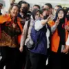 Petugas kepolisian menggiring Roy Suryo (kiri) dan Tifauzia Tyassuma (kanan) ke dalam gedung di Kejaksaan Nege