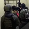 Personel Polri dari Satgas ODC saat mengiring YM masuk ke dalam sel tahanan di Polres Puncak, Sabtu (6/6/2026)