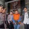 Bupati Kuantan Singingi (Kuansing) Suhardiman Amby (tengah) mengenakan rompi tahanan berjalan menuju mobil tah