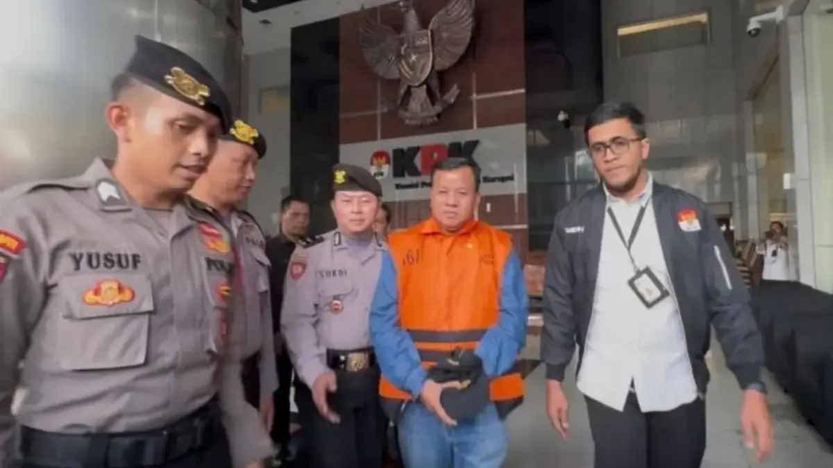 Bupati Kuantan Singingi (Kuansing) Suhardiman Amby (tengah) mengenakan rompi tahanan berjalan menuju mobil tah